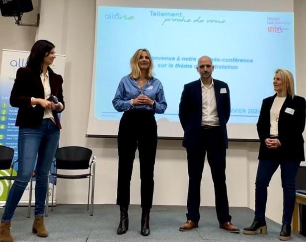 Conférence en entreprise, quatre personnes sur scène.