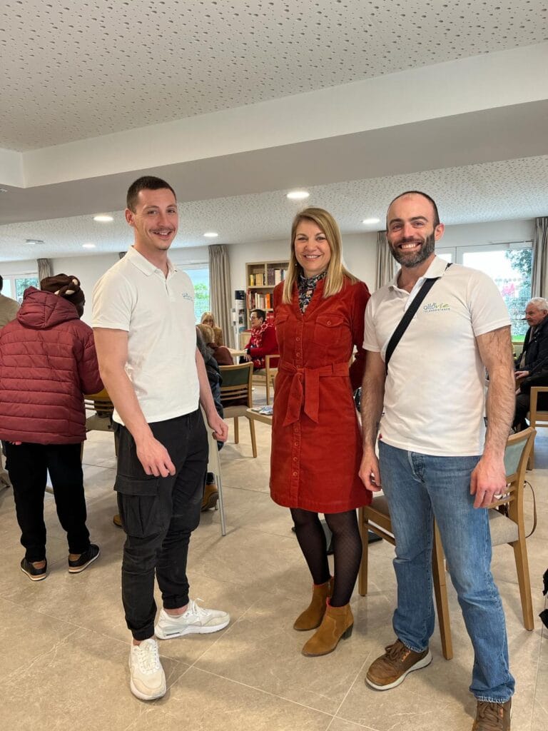 Trois personnes souriantes dans une salle de réunion.