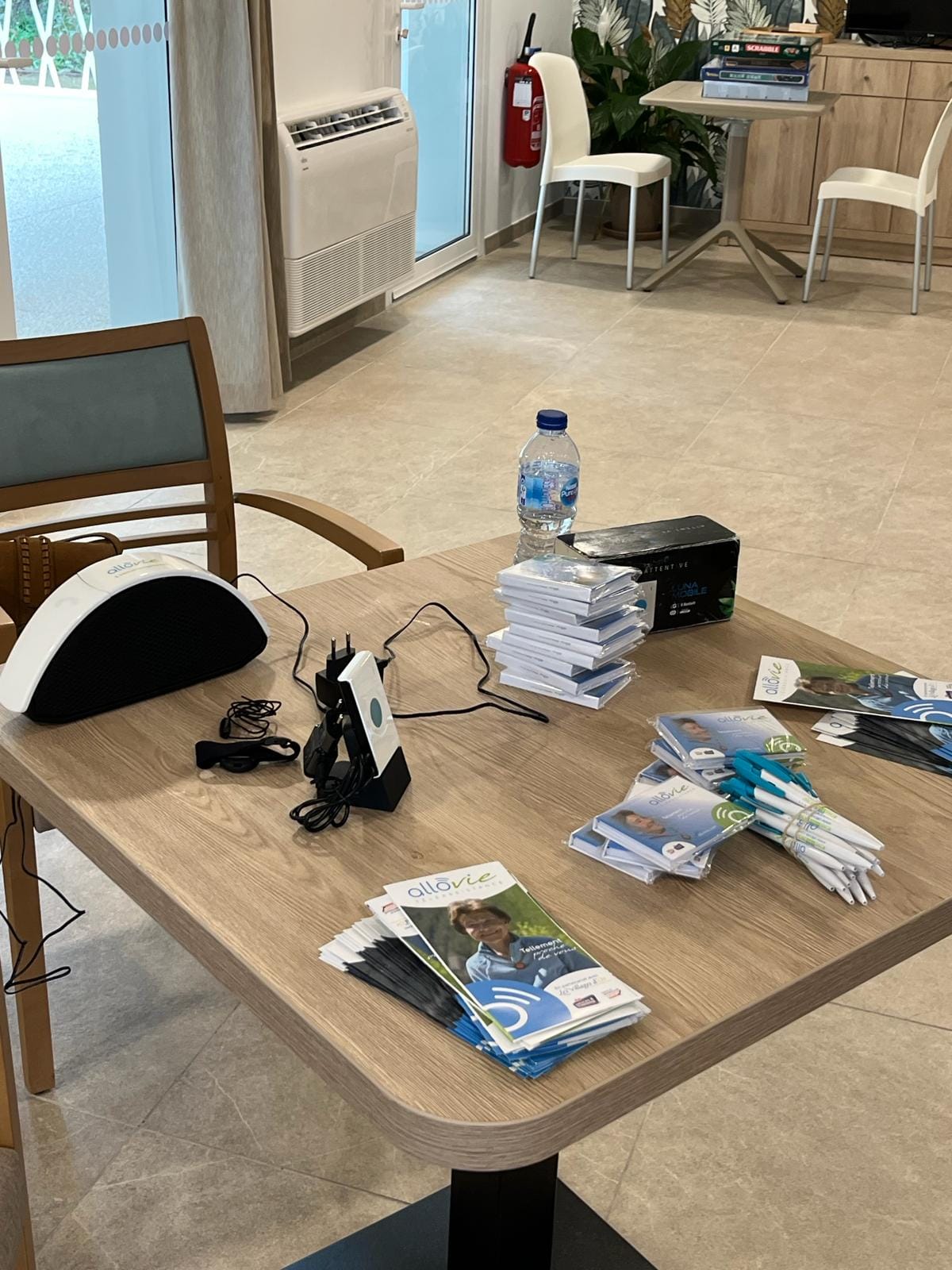 Brochures et stylos sur une table en bois.