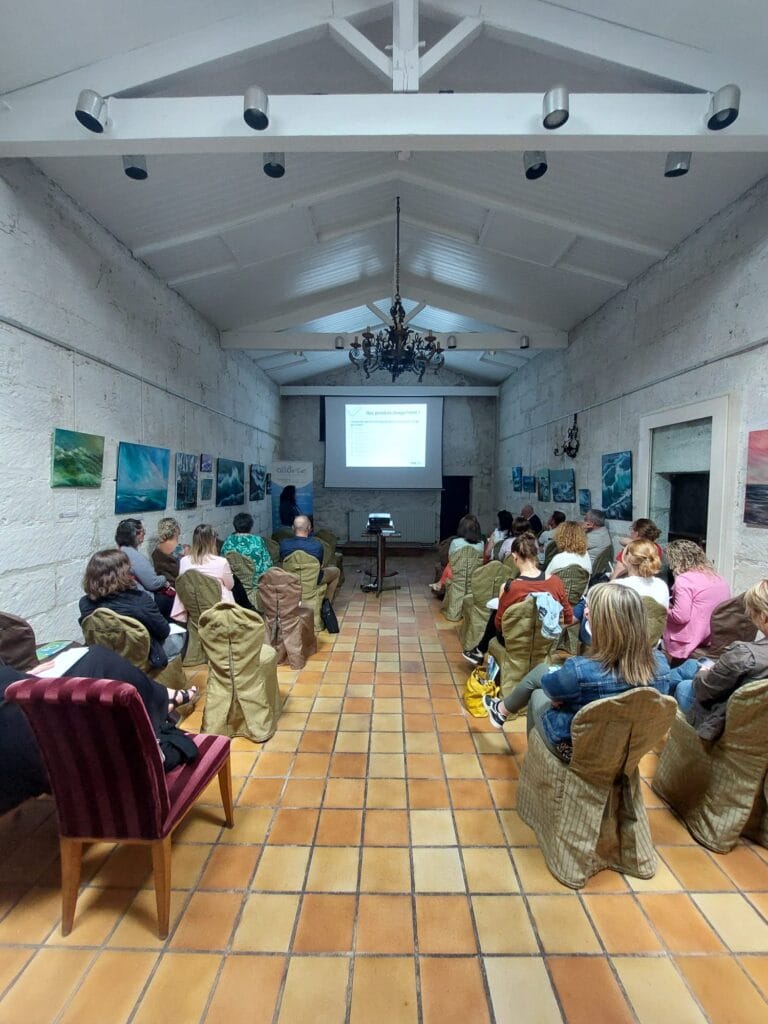 Conférence avec des participants attentifs dans une salle.
