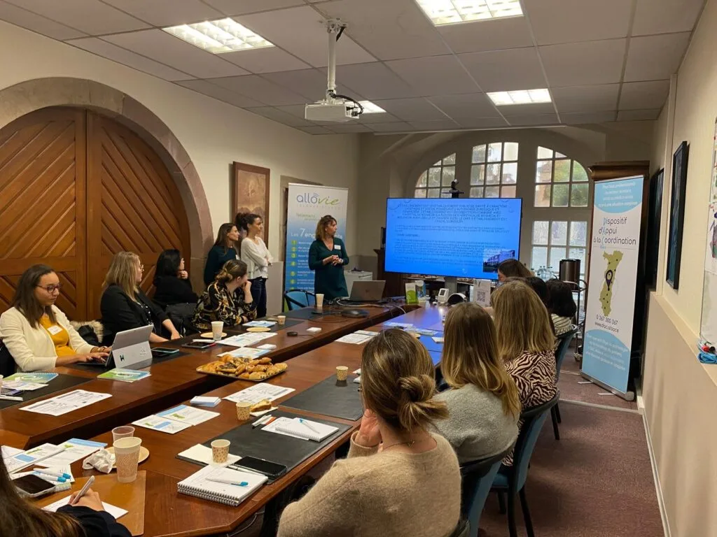 Réunion professionnelle autour d'une présentation PowerPoint.