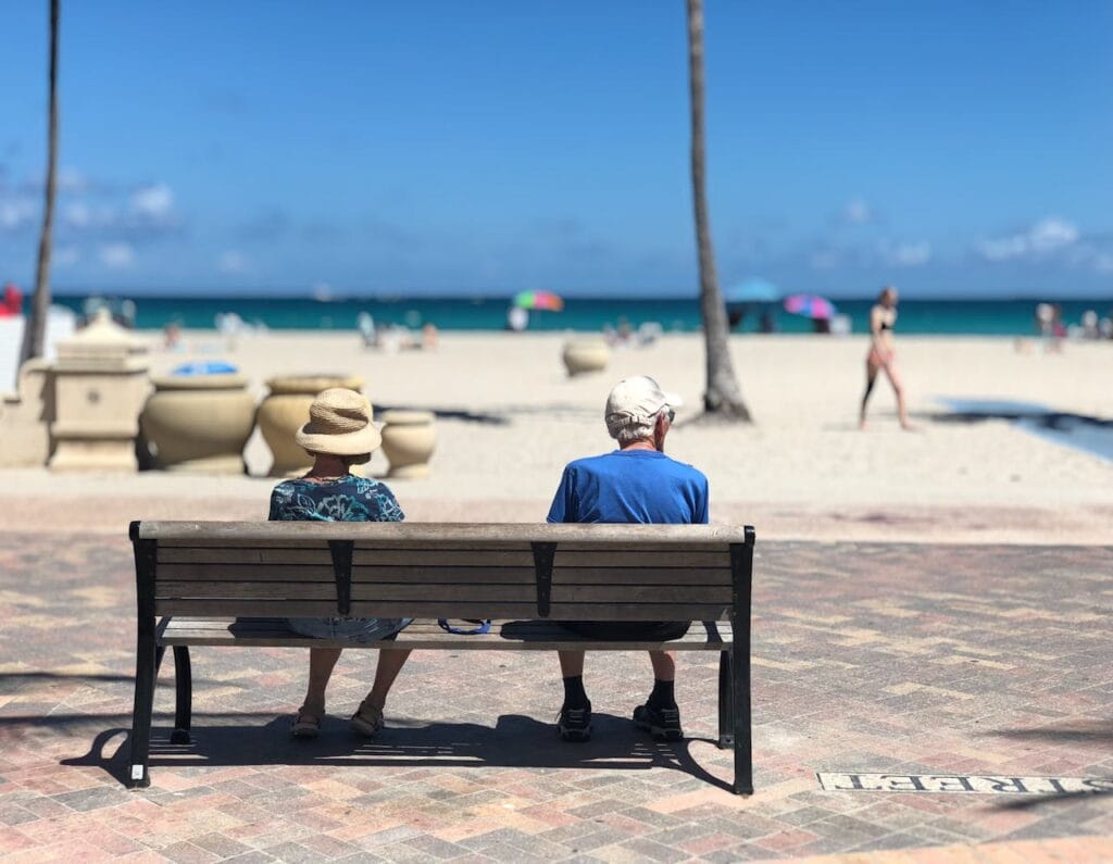 Couple âgé assis sur un banc à la plage.