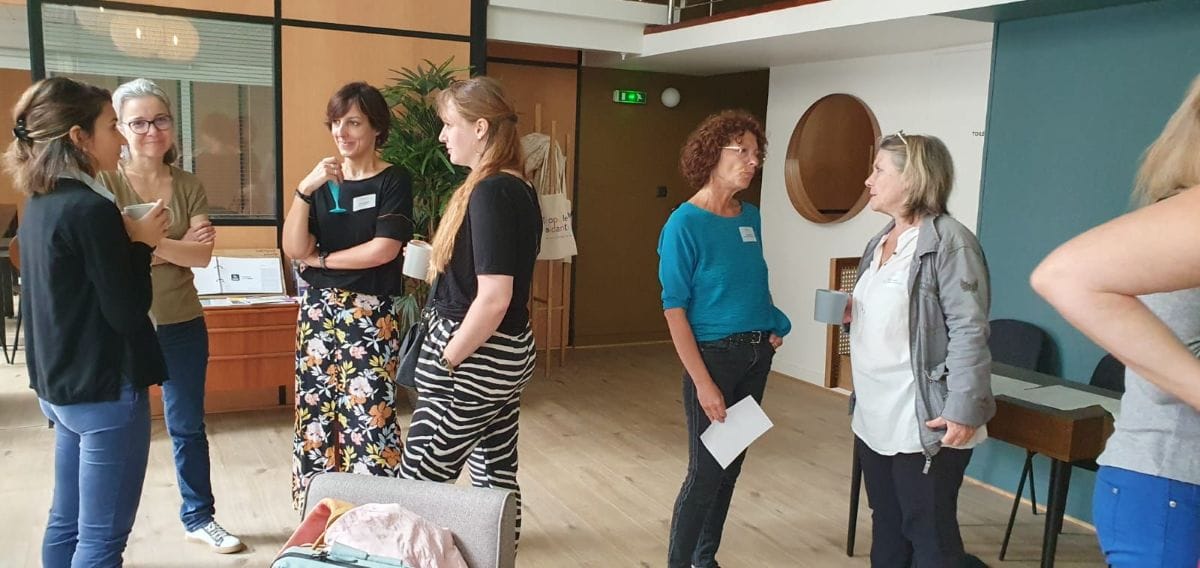 Groupe de personnes discutant dans un bureau moderne.