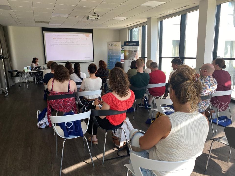 Présentateur devant auditoire lors d'une conférence en salle.