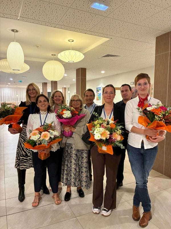 Groupe de personnes avec des bouquets de fleurs.