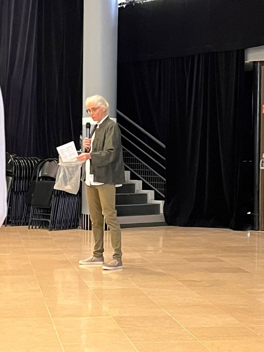 Personne parlant en public avec un microphone.