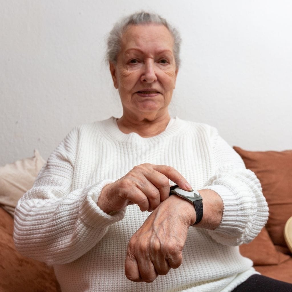 Femme portant une montre connectée chez elle.