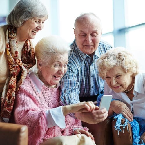 Groupe de seniors utilisant un smartphone heureux.
