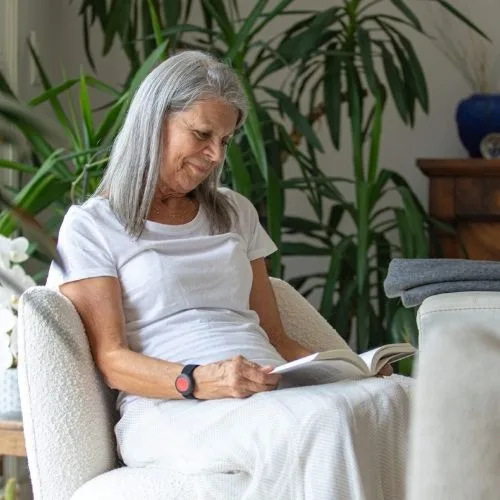 Femme âgée lisant dans un fauteuil.