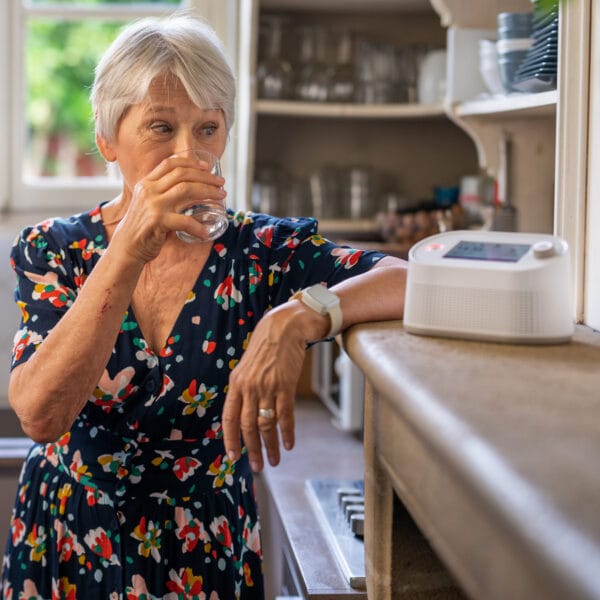 Femme buvant de l'eau dans la cuisine.