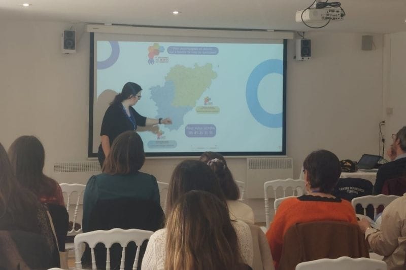 Présentation sur écran avec carte devant public.