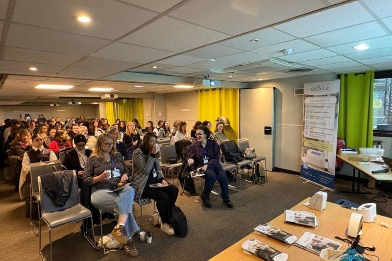 Conférence avec des participants attentifs dans une salle.
