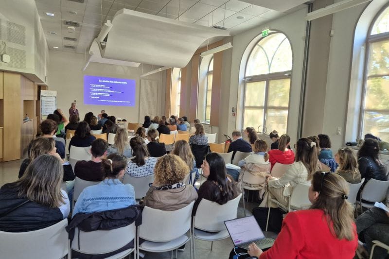 Conférence en salle avec public attentif.