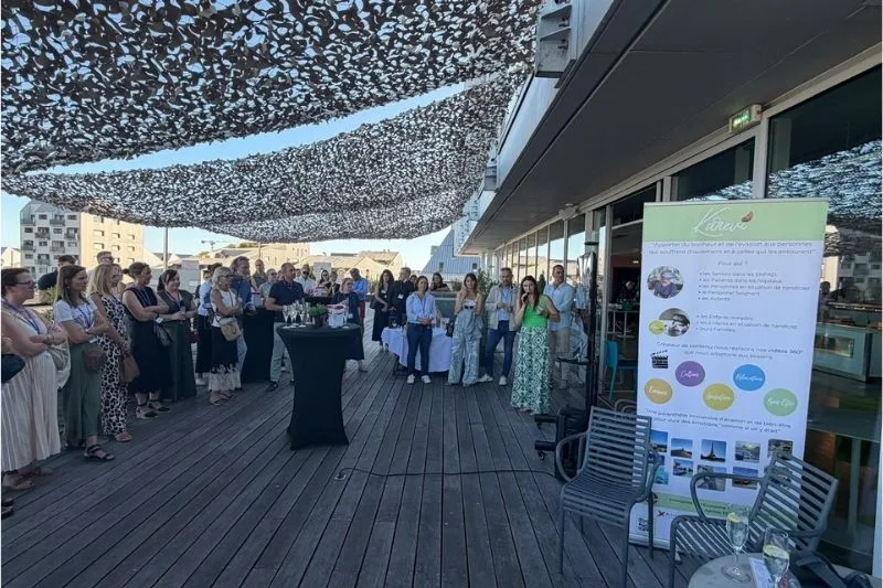 Réception en terrasse avec invités sous auvent ajouré.
