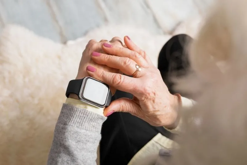 Personne âgée utilisant une montre connectée moderne.