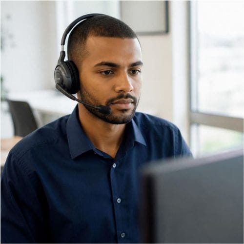 Homme au casque travaillant sur ordinateur, bureau moderne.