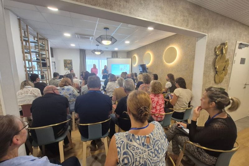 Présentation en salle devant un groupe attentif.